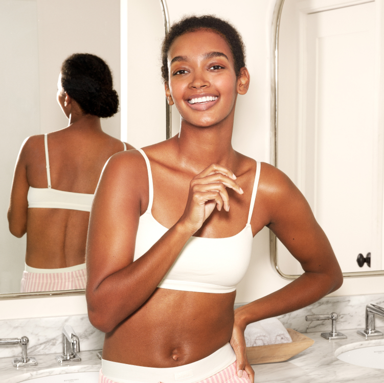 Smiling woman standing in front of bathroom vanity unit 